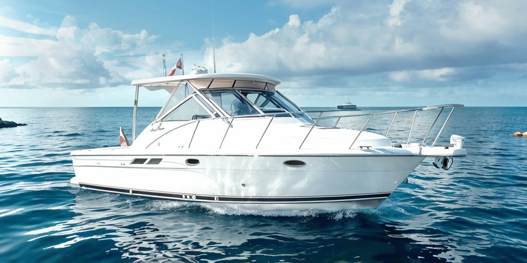 A white boat floating on the clear blue sea, under a vibrant blue sky dotted with soft, fluffy white clouds.